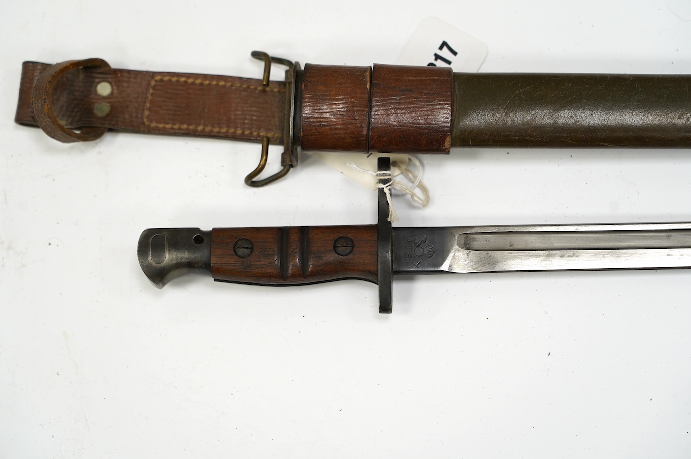 An American 1917 Remington bayonet, based on the earlier British bayonet of 1913, adapted for the 0.3 to 0.6 calibre rifles, with its leather covered scabbard. Condition - good